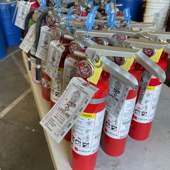 Row of fire extinguishers with fresh Lifeline state service tags attached